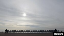 People sit on the blue chairs of the Promenade des Anglais before removal to avoid public gatherings during the second national lockdown to fight a second wave of the COVID-19 in Nice,&nbsp;France.