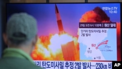 Seorang pria menonton layar TV di Stasiun Kereta Api Seoul di Seoul, Korea Selatan, yang menayangkan berita terkait peluncuran rudal Korea Utara, Minggu, 29 Maret 2020. (Foto: dok).