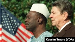 Le président du Mali, Moussa Traoré, avec son homologue américain Ronald Reagan, lors des cérémonies d'accueil pour l'arrivée du chef d'Etat malien aux Etats Unis, le 06 octobre 1988. (Photo by MIKE SARGENT / AFP)