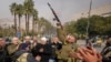 Opposition fighters celebrate the take over of the city by the insurgents in Damascus, Dec. 8, 2024. 