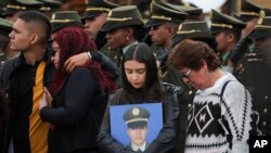 Relatives attend a ceremony marking one year since a car bomb attack on the police academy in Bogota, Colombia, Jan. 20, 2020.