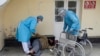 Trabajadores de salud en La Paz, Bolivia, ayudan a un hombre que yace en la calle en medio del brote del nuevo coronavirus, el 23 de julio de 2020.
