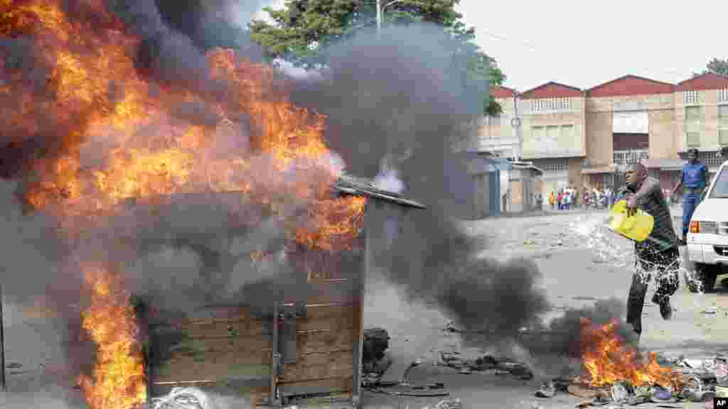 Umwe mu bari mu myiyerekano ariko asuka amazi ku mbeya z’ivyazibiye amabarabara biriko birasha yari yashizeho hamwe n’abandi, igihe umuriro watangura kwaka hejuru y’intsinga zitanga umuyangankuba muri Komine Buyenzi ku murwa mukuru w’Uburundi, Bujumbura, ku musi wa kabiri, italiki 26 z’ukwezi kwa gatanu, umwaka w’2015.