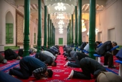 FILE - Uyghurs and other members of the faithful pray at the Id Kah Mosque in Kashgar in western China's Xinjiang Uyghur Autonomous Region, as seen during a government organized trip for foreign journalists, April 19, 2021.