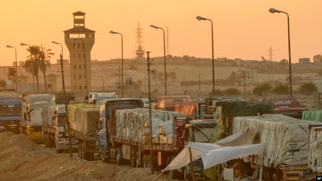 FILE - Trucks of humanitarian aids wait to cross the Rafah border crossing between Egypt and the Gaza Strip, in Rafah, Egypt, Sept. 9, 2024.