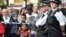 A young boy plays with a water pistol as onlookers stand at the police cordon as police search a property in Barking Road, east London, June 4, 2017.