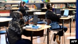 (FILES) In this file photo taken on November 16, 2020 Students sit with their laptop computers at St. Joseph Catholic School in La Puente, California where pre-kindergarten to Second Grade students in need of special services returned to the classroom…