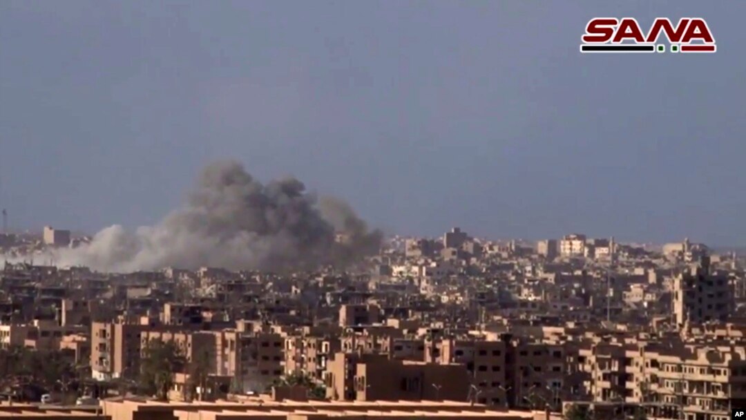 Foto yang diambil dari gambar video yang dirilis kantor berita SANA pada 2 November 2017 menunjukkan asap dan puing-puing setelah pemerintah Suriah menembaki Kota Deir al-Zor dalam serangan melawan militan ISIS.