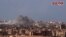 Esta imagen tomada de un video divulgado el 2 de noviembre de 2017 por la agencia oficial de noticias siria SANA, muestra humo tras el bombardeo del Ejército sirio contra militantes de ISIS en Deir el-Zour, Siria.