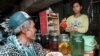 FILE PHOTO - A Cambodian customer waits for a glass of the popular local rice wine at a Phnom Penh street stall. (REUTERS)