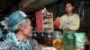 FILE PHOTO - A Cambodian customer waits for a glass of the popular local rice wine at a Phnom Penh street stall. (REUTERS)