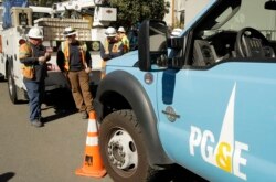 Pacific Gas & Electric and CalTrans workers stand near the Caldecott Tunnel in Oakland, Calif., Oct. 9, 2019.