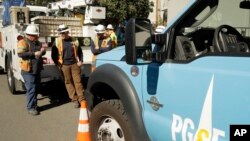 Pacific Gas & Electric and CalTrans workers stand near the Caldecott Tunnel in Oakland, Calif., Oct. 9, 2019.