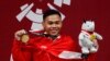 Atlet angkat besi Indonesia, Eko Yuli Irawan, menunjukkan medali emas yang dimenangkan untuk nomor putra 62 kg di Asian Games 2018, di Jakarta International Expo Kemayoran, 21 Agustus 2018. (Foto: Reuters)