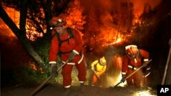 Firefighters create a firebreak near a home in Middletown, California, Sept. 13, 2015. 