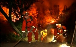 FILE - Firefighters create a firebreak near a home in Middletown, Calif., Sept. 13, 2015.