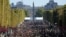 FILE - People walk on the Champs Elysees during the "day without cars," in Paris, Sept. 27, 2015.