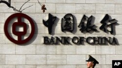 A paramilitary policeman stands guard outside the headquarters of the Bank of China in central Beijing, March 18, 2011. (file photo)