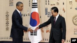 US President Barack Obama, left, shakes hands with South Korean President Lee Myung-bak at the Blue House, the official presidential house, in Seoul, South Korea, Sunday, March 25, 2012.