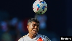 El mediocampista peruano Wilder Cartagena cabecea el balón durante la primera mitad del partido de la Copa América contra Canadá.
