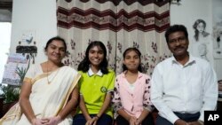 FILE - Gautam Dongre, of the National Alliance of Sickle Cell Organizations, sits with his daughters, Sumedha, 13, second right, a patient of sickle cell disease, and Rushali, 15, and his wife, Padmashri, at their residence in Nagpur, India, December 6, 2023.