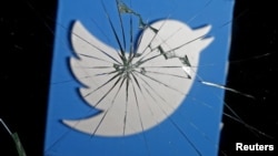 A 3D-printed Twitter logo is seen through broken glass, in this picture illustration taken Feb. 8, 2016.