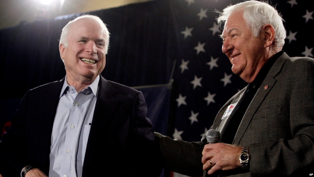 FILE - Sen. John McCain, R-Ariz., left, smiles as he gets a pat on the back from longtime friend and supporter Lt. Col. Orson Swindle, USMC Ret., Feb. 18, 2010, at a rally in Phoenix, Arizona.