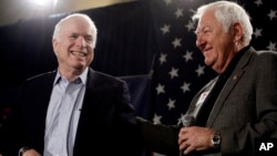 FILE - Sen. John McCain, R-Ariz., left, smiles as he gets a pat on the back from longtime friend and supporter Lt. Col. Orson Swindle, USMC Ret., Feb. 18, 2010, at a rally in Phoenix, Arizona.