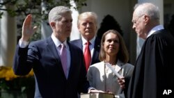 President Donald Trump watches as Supreme Court Justice Anthony Kennedy administers the judicial oath to Judge Neil Gorsuch during a re-enactment in the Rose Garden of the White House White House in Washington, April 10, 2017. 
