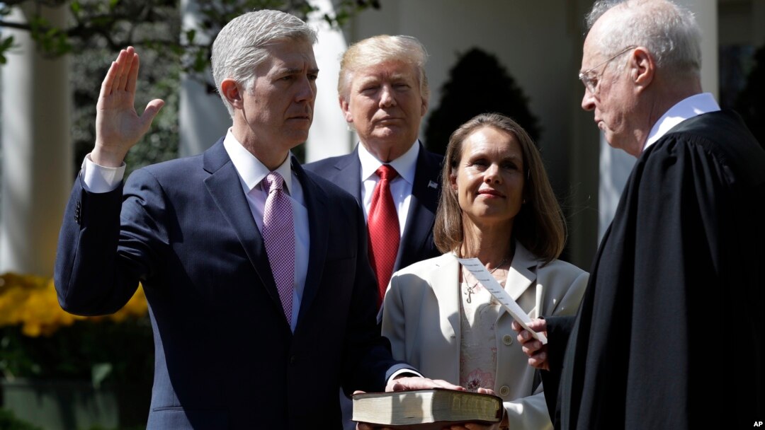 President Donald Trump watches as Supreme Court Justice Anthony Kennedy administers the judicial oath to Judge Neil Gorsuch during a re-enactment in the Rose Garden of the White House White House in Washington, April 10, 2017. 
