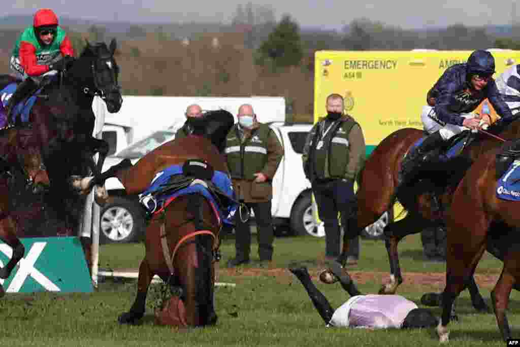 Getaway Trump and Harry Cobden fall during the Close Brothers Red Rum Handicap Chase on the first day of the Grand National Festival at Aintree Racecourse in Liverpool, north west England.