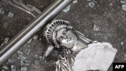 A broken Statue of Liberty figure is seen between glass shatters outside a looted souvenir shop after a night of protests over the death of African-American George Floyd in Minneapolis, in Manhattan in New York City, June 2, 2020. 