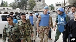 The Chief of the U.N. Supervision Mission to Syria, Norwegian Major General Robert Mood (2nd R) and his team walk with members of the Free Syrian Army, at the Khalidiya neighborhood during the United Nations observers' visit to Homs, May 3, 2012.