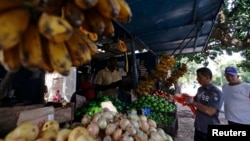 FILE - People buy food at a privately-licensed fruit and vegetable stall in Havana, Cuba, Feb. 1, 2012.