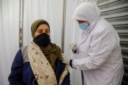 A Palestinian member of the education staff receives a dose of Sinopharm vaccine against the coronavirus as schools are set to reopen partially, in Tubas in the Israeli-occupied West Bank, April 6, 2021.