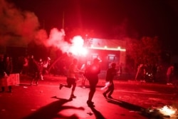 FILE - Demonstrators clash with police during protests following the impeachment of President Martin Vizcarra, in Lima, Peru, Nov. 12, 2020.