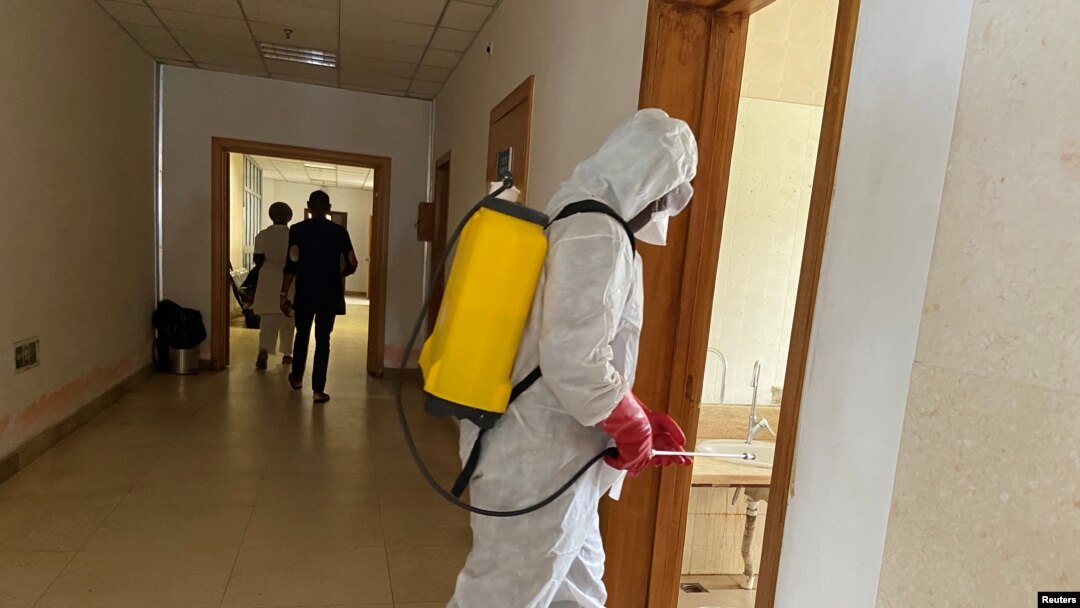 FILE - A health agent wearing protective equipment, disinfects the corridors amid the spread of the coronavirus disease (COVID-19), at an hospital in Douala, Cameroon, April 27, 2020. 