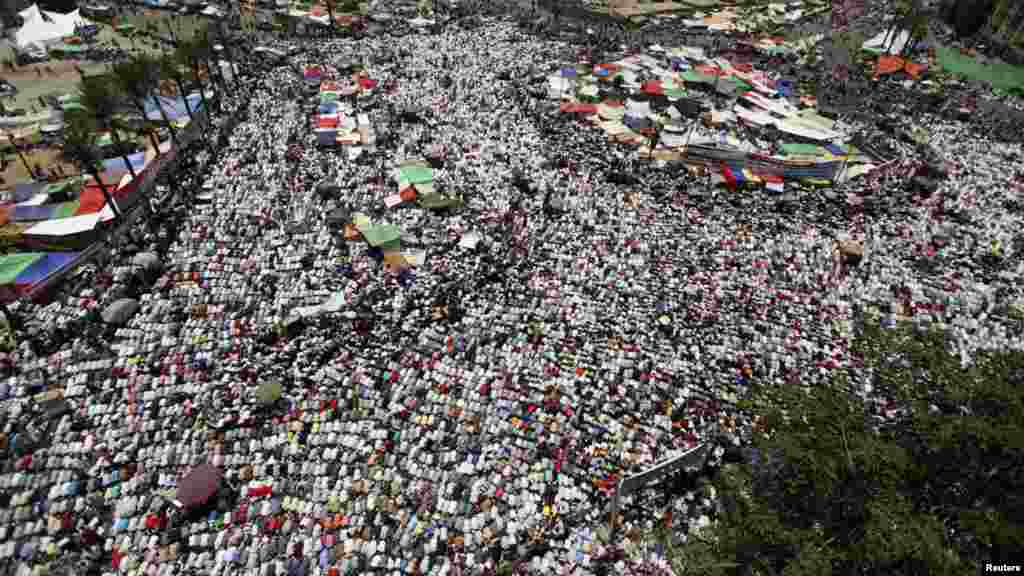 People attend Friday prayers before a demonstration against the Supreme Council for the Armed Forces (SCAF) in Tahrir Square.