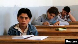 FILE - Students sit for their exam in what activists say is the only school in Hama not controlled by the Syrian regime, located in an area controlled by the Free Syrian Army, in Hama countryside, May 10, 2014. 