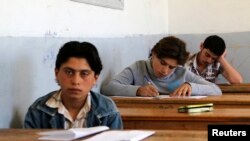 FILE - Students are seen taking exams in Hama, Syria, May 10, 2014. 