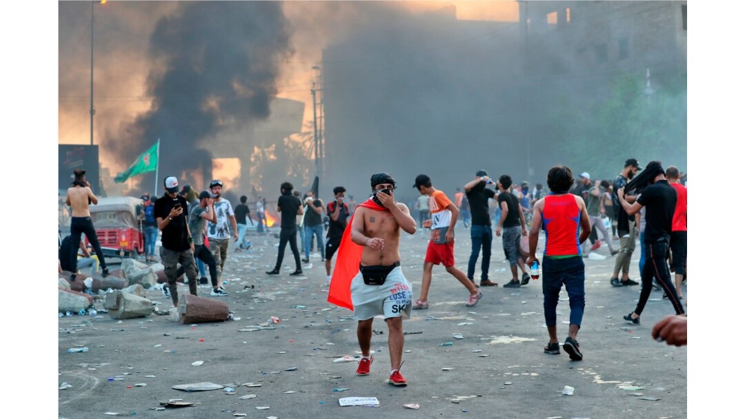 Anti-government protesters set fires and close a street during a demonstration in Baghdad, Oct. 3, 2019.
