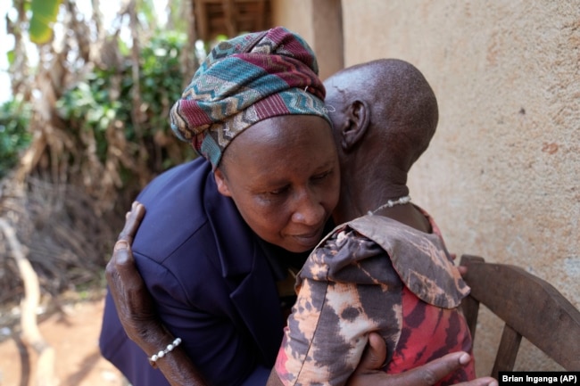 Emelyne Nzeyimana, left, and Prudencienne Namukobwa, perform akazehe, a Burundian traditional form of musical greeting performed exclusively by women, outside her home in Ngozi, Burundi, Friday, Sept. 20, 2024. (AP Photo/Brian Inganga)