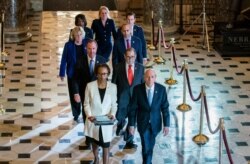 FILE - Clerk of the House Cheryl Johnson, left, and House Sergeant at Arms Paul Irving pass through Statuary Hall at the Capitol to deliver the articles of impeachment against President Donald Trump to the Senate, on Capitol Hill, Jan. 15, 2020.