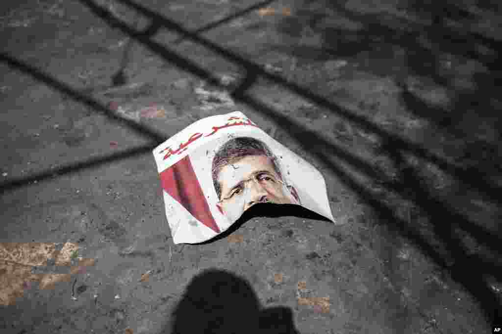 Potongan poster presiden terguling Mohamed Morsi tergeletak di pelataran masjid Rabaah Al-Adawiya di kota Nasr, Kairo, 21 Agustus 2013