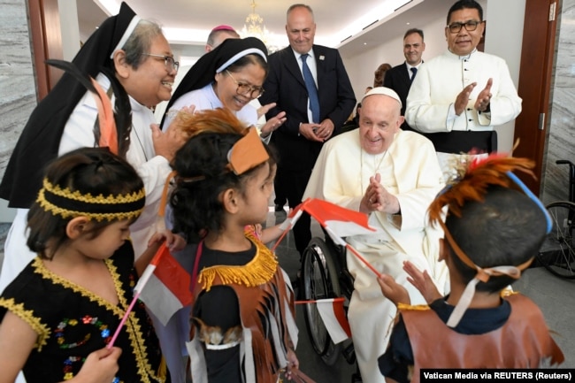 Paus Fransiskus berinteraksi dengan anak-anak dalam kunjungannya di Jakarta, 3 September 2024. (Foto: Vatican Media via REUTERS)