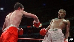 Petinju Pernell Whitaker (kanan) menghindari pukulan yang dilesakkan oleh Oscar De La Hoya dalam pertarungan memperebutkan gelar WBC Welterweight Championship di Thomas & Mack Center di Las Vegas, pada 12 April 1997. (Foto: AP)