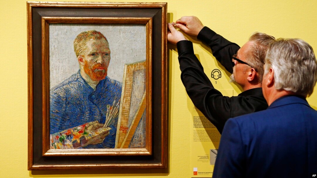 Kurator memasang lukisan potret Vincent Van Gogh yang digambar sendiri oleh sang seniman, di Museum Van Gogh di Amsterdam, Belanda.