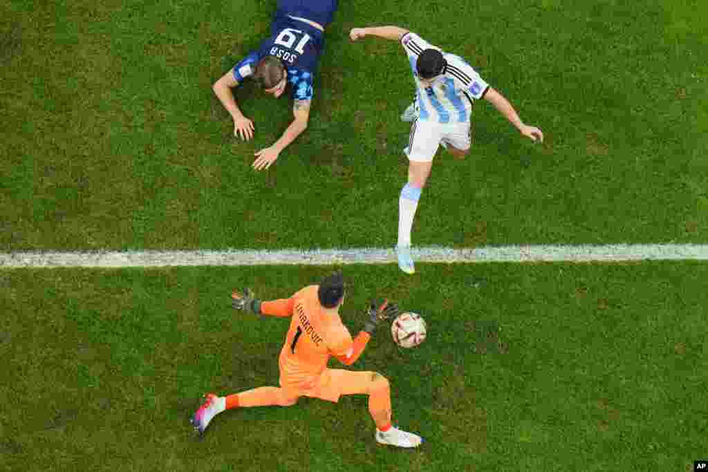 El argentino Julian Alvarez anota el segundo gol de su equipo superando al arquero croata Dominik Livakovic durante el partido de semifinales de la Copa del Mundo el martes 13 de diciembre de 2022. (AP Foto/Hassan Ammar)