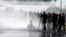 Protestors are sprayed with water by Argentine police as they block a road during a 24-hour national strike in Buenos Aires, Argentina, April 6, 2017.