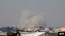 2024 年 6 月 21 日，以色列和哈馬斯在加沙的武裝衝突還在持續。圖為從加沙南部汗尤尼斯的一個難民營看到的拉法城遭到轟炸後濃煙滾滾的景象。